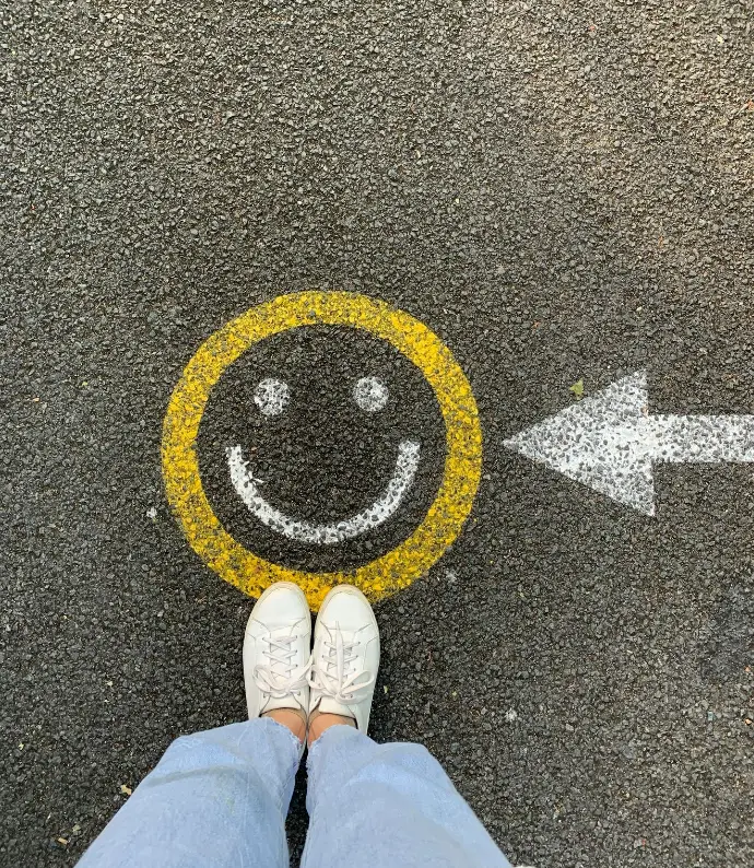 person in white shoes standing on gray concrete road