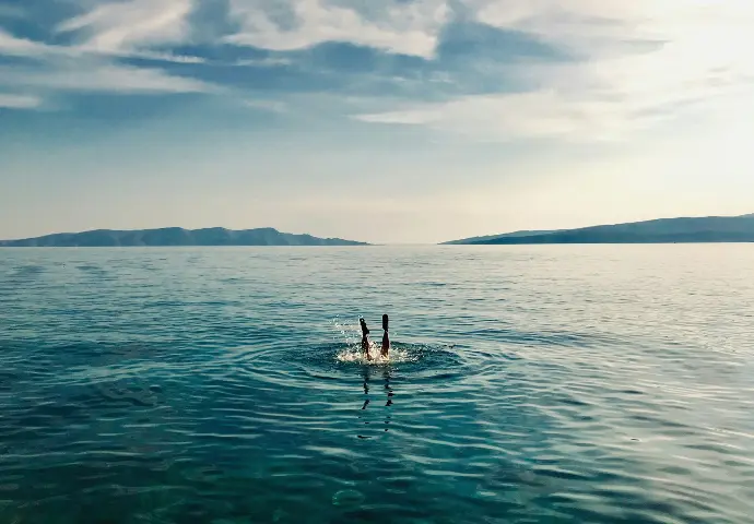 person in blue water during daytime